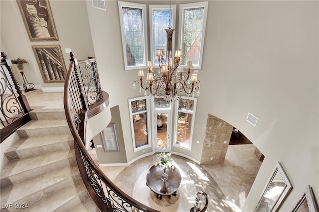 interior space featuring a towering ceiling and a chandelier