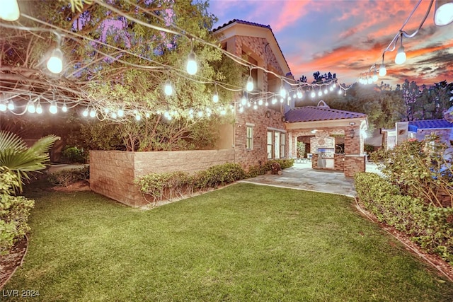 yard at dusk featuring a patio area