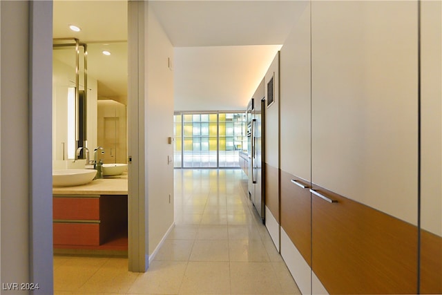 corridor with light tile patterned flooring and sink