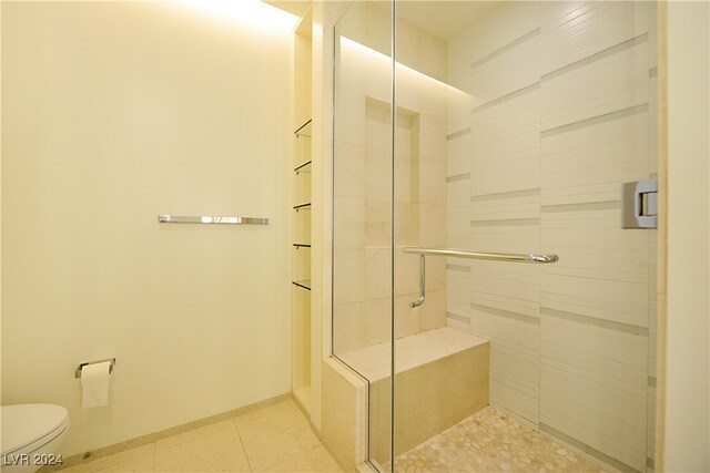 bathroom with toilet and an enclosed shower