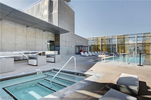 view of swimming pool featuring a community hot tub and a patio area