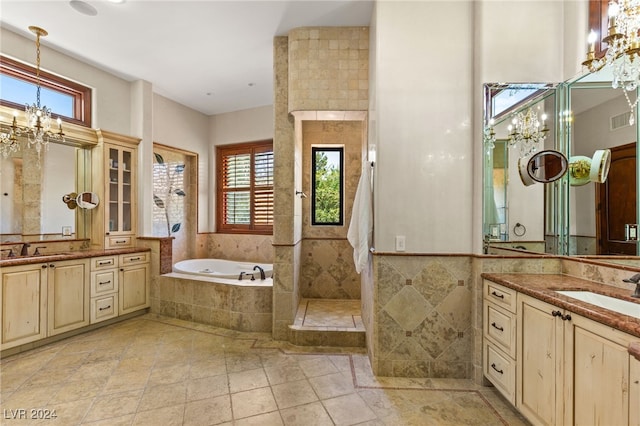 bathroom with vanity, tile walls, a chandelier, and separate shower and tub