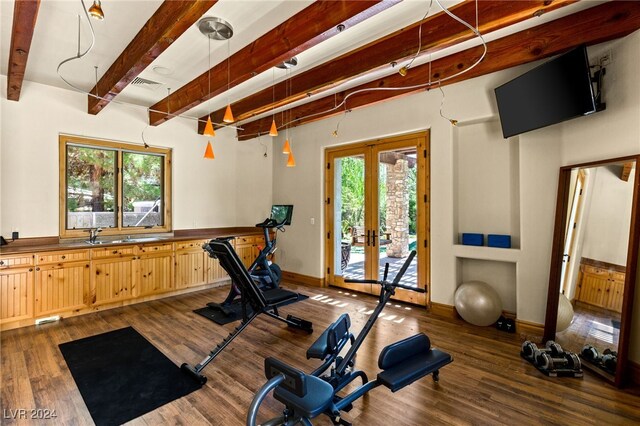 workout room with a wealth of natural light, dark hardwood / wood-style floors, and french doors