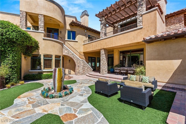 back of property with an outdoor living space, a patio, and a balcony