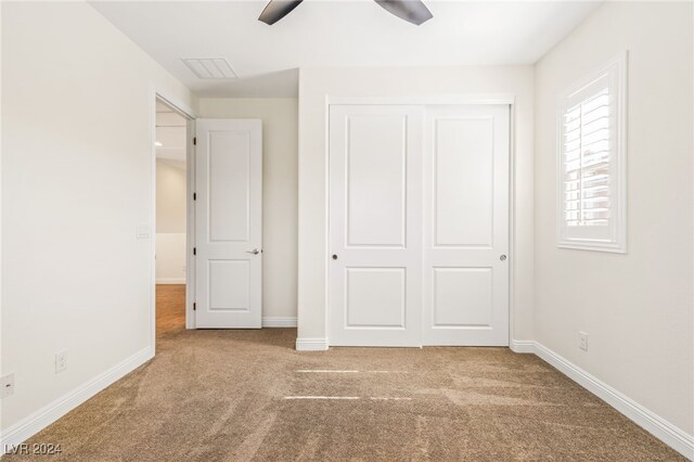 unfurnished bedroom featuring a closet, carpet, and ceiling fan