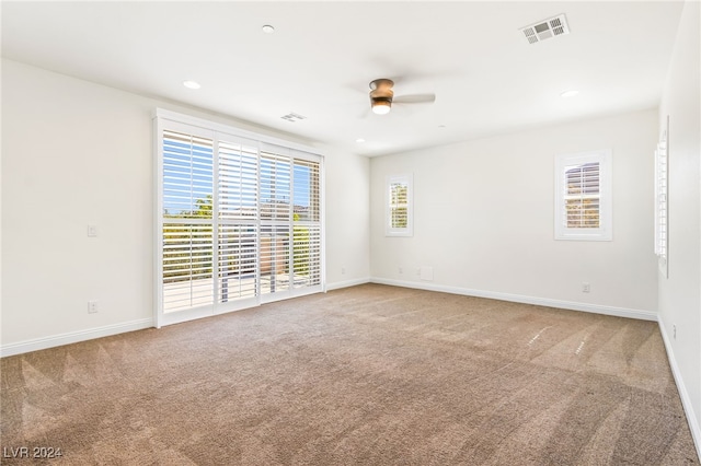 carpeted spare room featuring ceiling fan