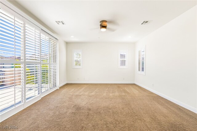 carpeted empty room featuring ceiling fan