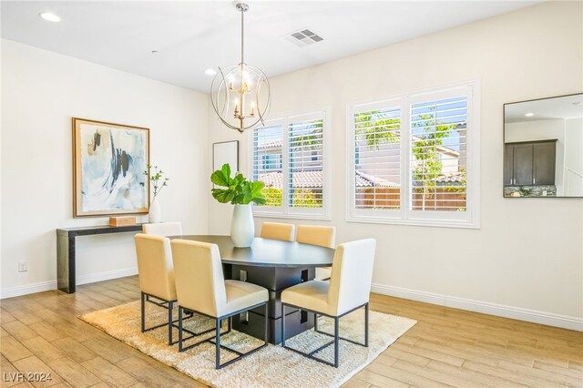 dining space with a notable chandelier and light hardwood / wood-style flooring