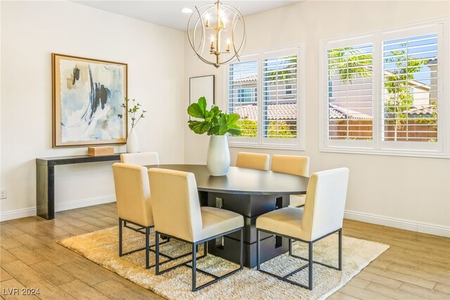 dining area with light hardwood / wood-style floors and a chandelier