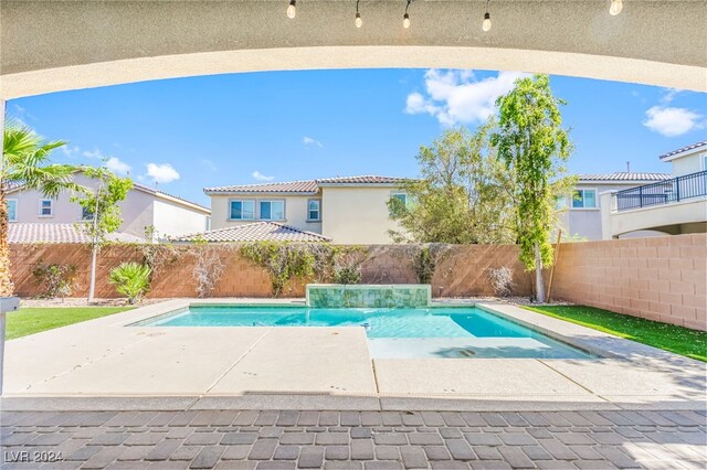 view of pool featuring pool water feature and a patio