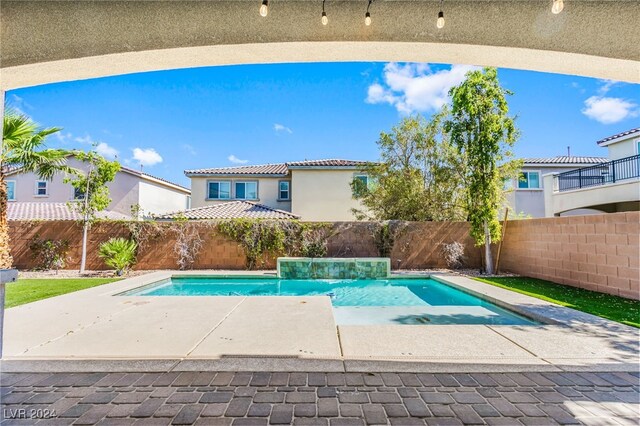 view of swimming pool featuring pool water feature and a patio area