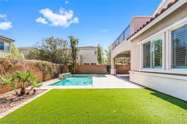 view of swimming pool featuring a yard and a patio