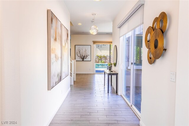 corridor with light hardwood / wood-style floors