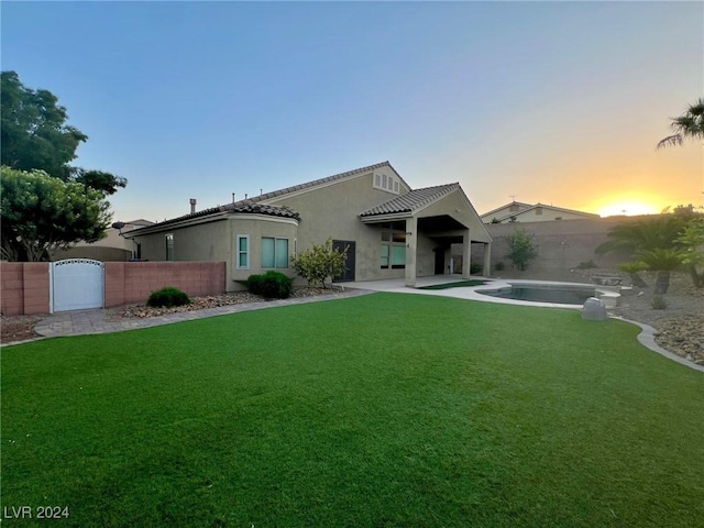 view of front of house featuring fence private yard, stucco siding, a gate, and a front lawn
