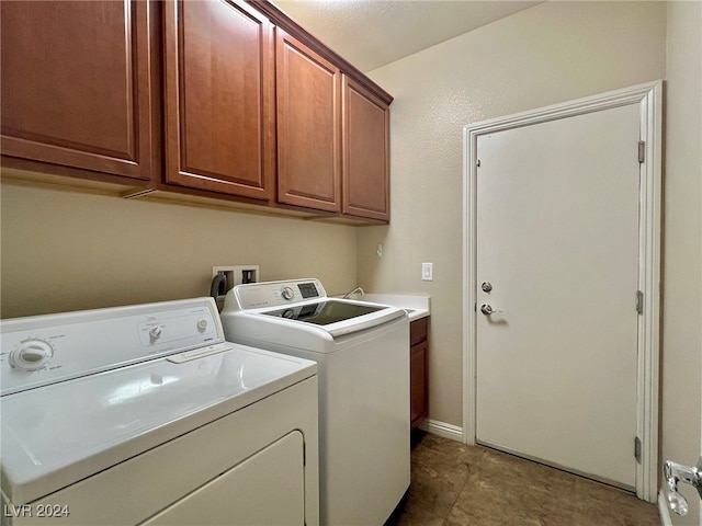 laundry area with washing machine and dryer, cabinets, and sink