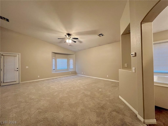 carpeted empty room with visible vents, baseboards, a ceiling fan, and lofted ceiling