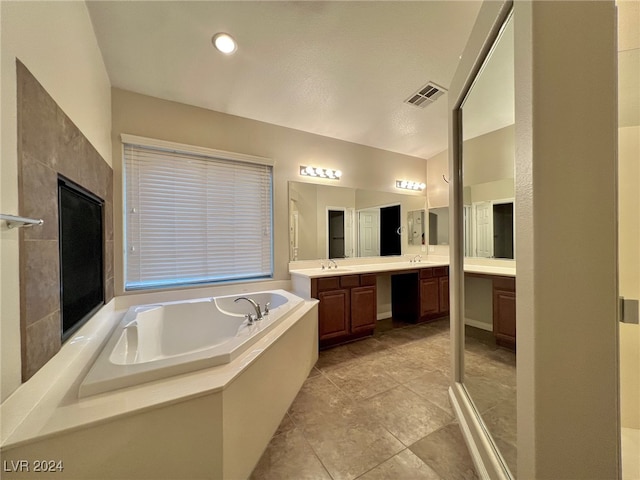 bathroom featuring tile patterned floors, independent shower and bath, and vanity