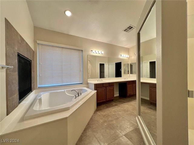 bathroom with visible vents, a bath, vanity, and tile patterned floors