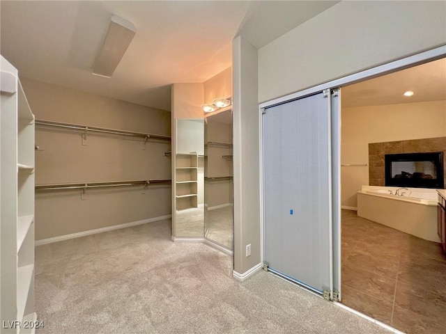 full bath featuring a tub to relax in, baseboards, and a walk in closet
