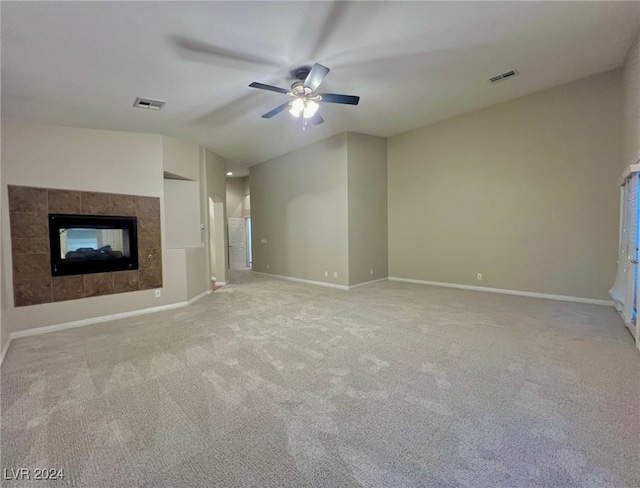 unfurnished living room with ceiling fan, light colored carpet, a fireplace, and vaulted ceiling