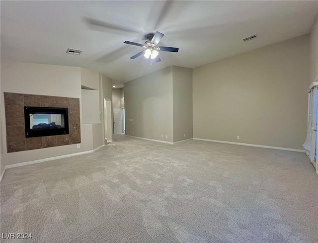 unfurnished living room featuring a ceiling fan, vaulted ceiling, visible vents, light carpet, and baseboards