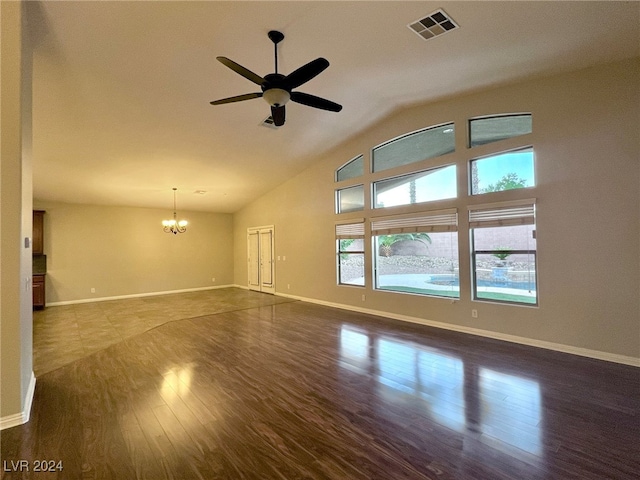 unfurnished living room featuring ceiling fan with notable chandelier, dark wood-type flooring, and vaulted ceiling