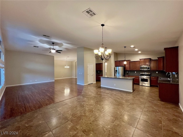 kitchen with ceiling fan with notable chandelier, stainless steel appliances, dark hardwood / wood-style flooring, a center island, and hanging light fixtures