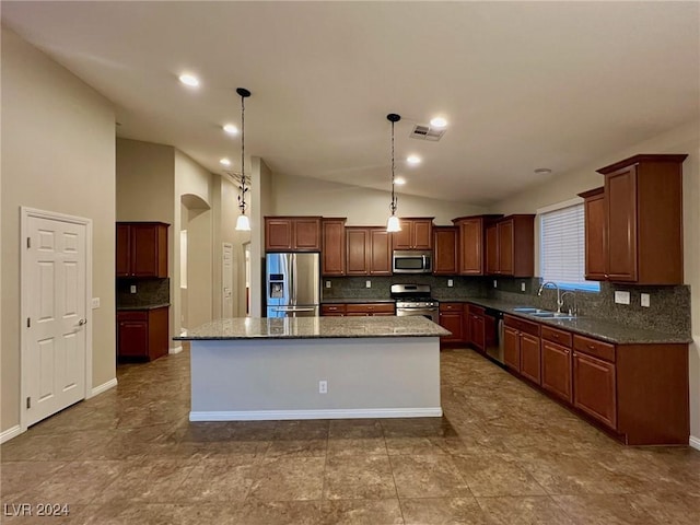 kitchen with visible vents, appliances with stainless steel finishes, a sink, lofted ceiling, and decorative backsplash