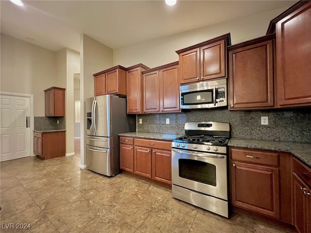 kitchen featuring backsplash, stainless steel appliances, and dark stone counters