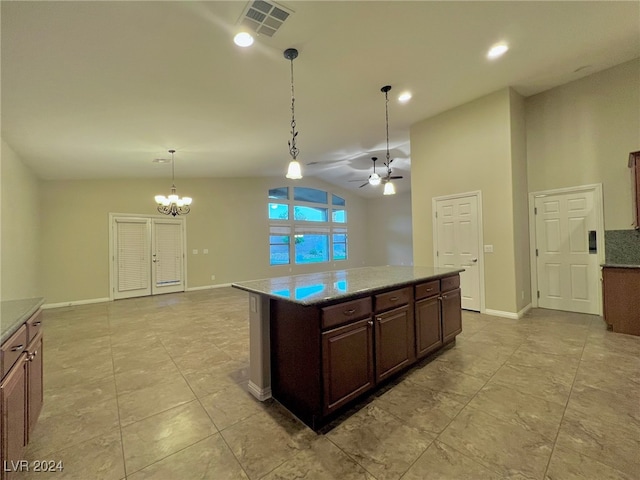 kitchen featuring ceiling fan with notable chandelier, pendant lighting, a center island, lofted ceiling, and dark brown cabinetry