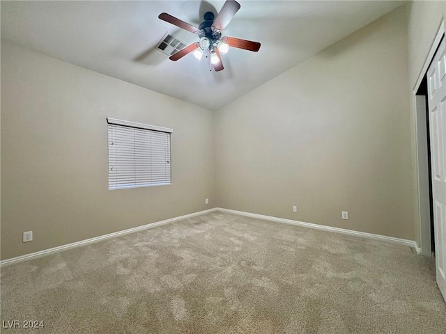 carpeted empty room with vaulted ceiling, baseboards, a ceiling fan, and visible vents