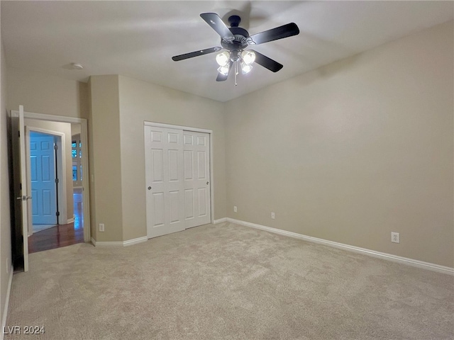 unfurnished bedroom with a closet, ceiling fan, and light carpet