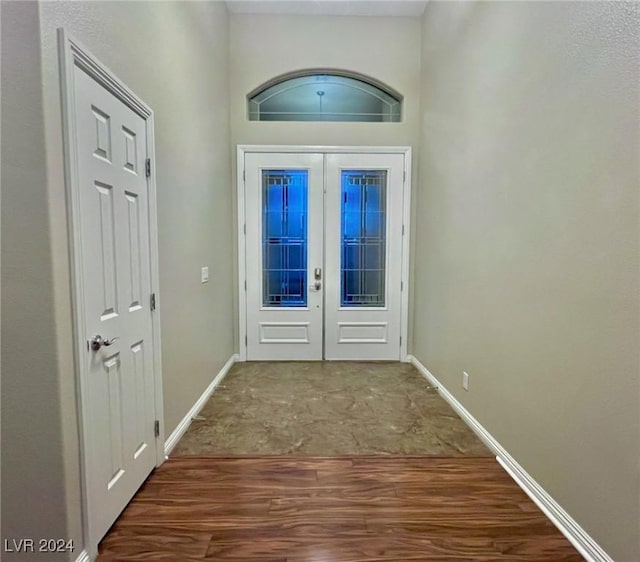 entryway featuring french doors, wood finished floors, and baseboards