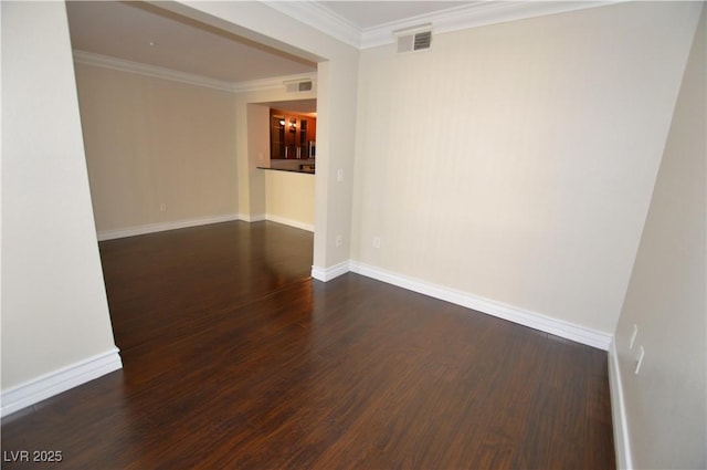 spare room featuring dark wood-type flooring and crown molding