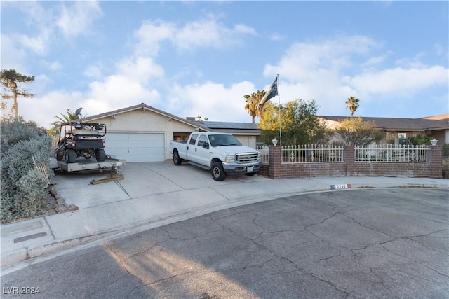 ranch-style house featuring solar panels and a garage