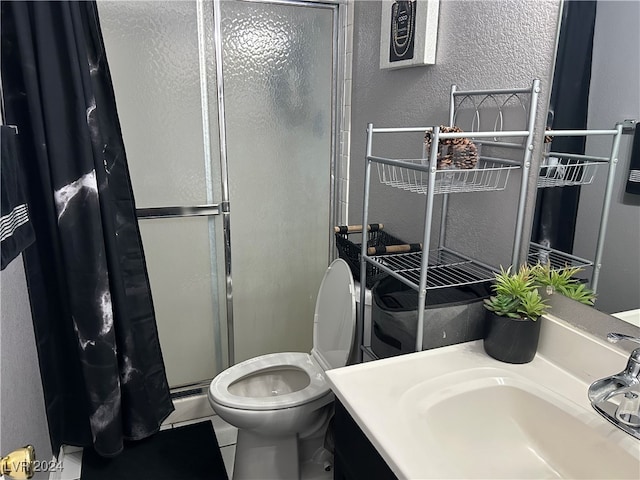 bathroom featuring vanity, toilet, tile patterned floors, and a shower with door