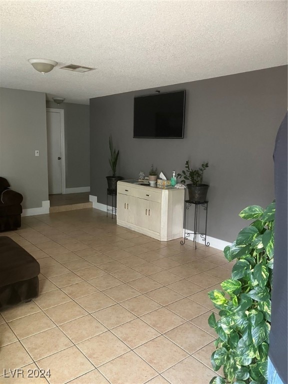 unfurnished living room with light tile patterned floors and a textured ceiling