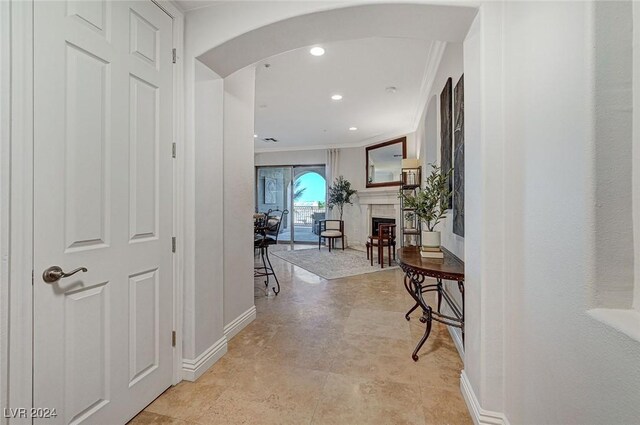 hallway featuring recessed lighting, arched walkways, ornamental molding, and baseboards