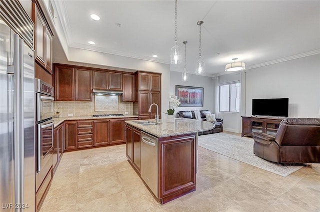 kitchen with light stone counters, stainless steel appliances, a sink, tasteful backsplash, and open floor plan
