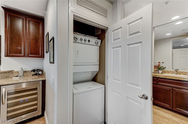 washroom with indoor wet bar, beverage cooler, and stacked washer and dryer