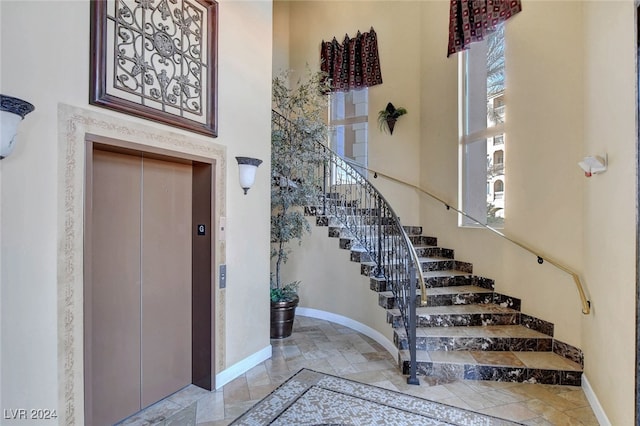 foyer entrance featuring elevator and a high ceiling