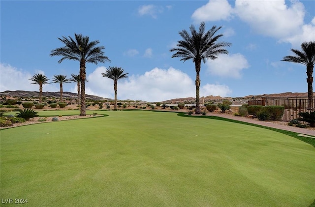 view of property's community with fence, golf course view, and a mountain view