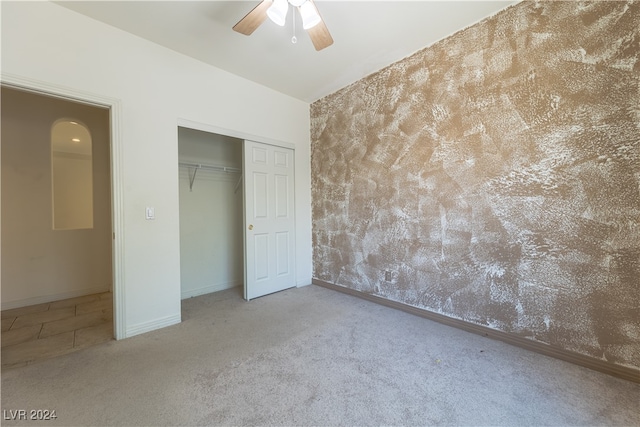 unfurnished bedroom featuring carpet flooring, ceiling fan, and a closet