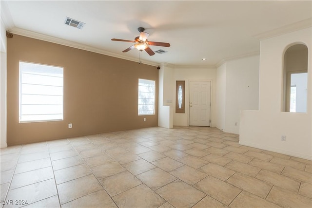 unfurnished room featuring visible vents, arched walkways, ornamental molding, and a ceiling fan