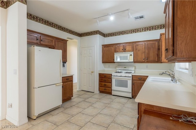 kitchen with a sink, white appliances, brown cabinetry, and light countertops