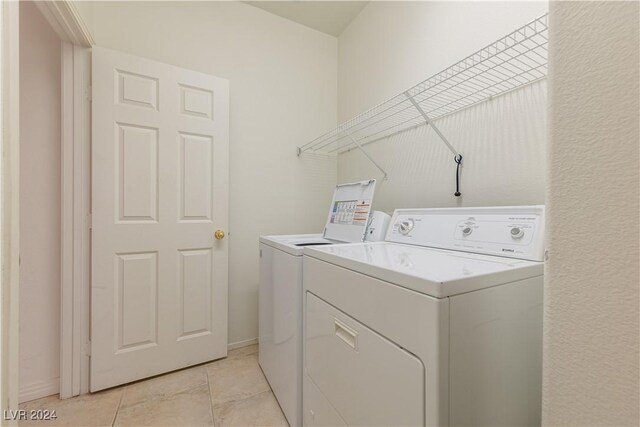 washroom featuring light tile patterned flooring and washing machine and dryer