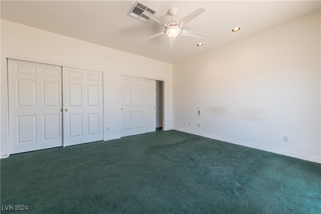 unfurnished bedroom with two closets, dark colored carpet, and ceiling fan