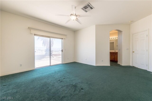 empty room with ceiling fan and dark carpet