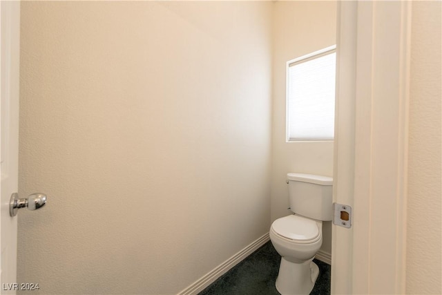bathroom featuring toilet and baseboards