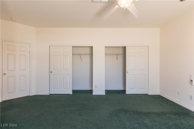 unfurnished bedroom with ceiling fan, multiple closets, and dark colored carpet